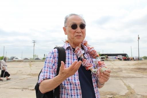 A man holds a piece of concrete as he talks to the camera