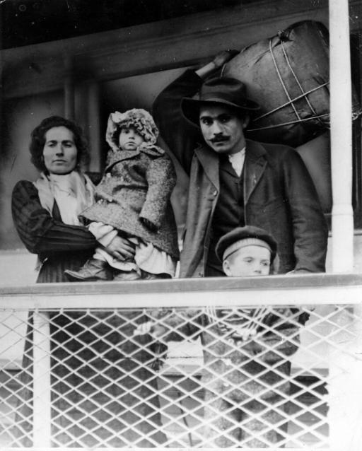Immigrant family on a ship. Man holds their bundle of possessions on his back.