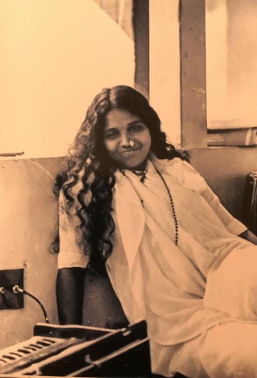 photo of young Indian woman sitting near a window with long hair down