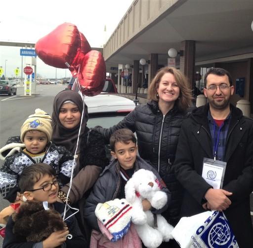 A Syrian refugee family poses in front of the airport after being resettled to Ohio.