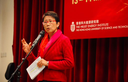 A woman in a red suit at a podium