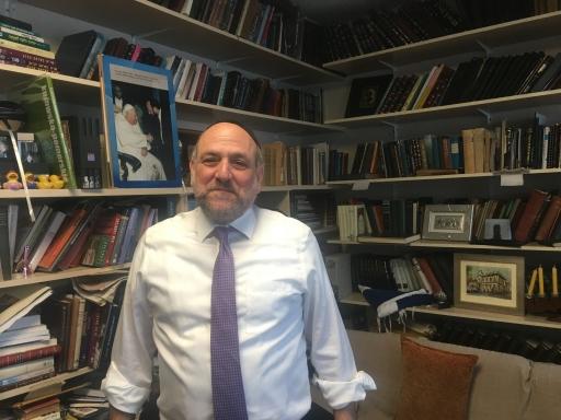 Chief rabbi of Poland in his office full of books on shelf. 