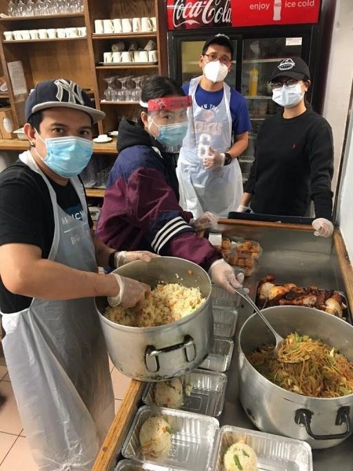 Workers at Amazing Grace restaurant in Woodside, Queens, prepare rice and pansit noodles for delivery to Filipino health workers in the area.