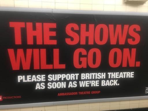 A red sign in a London tube station supports West End theaters. 