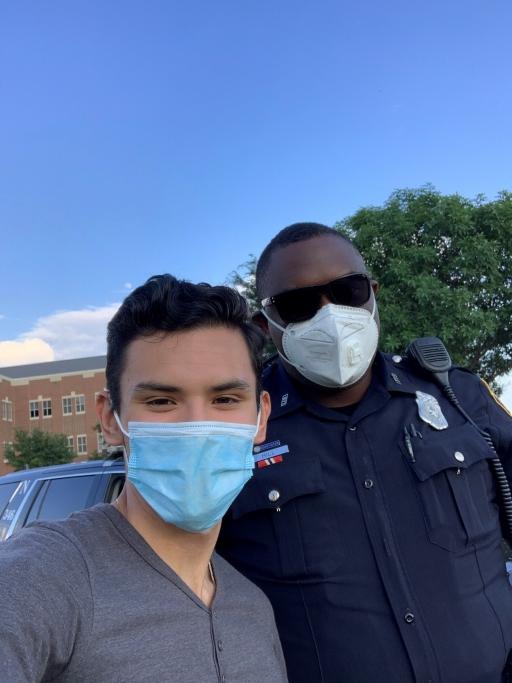 Izcan Ordaz, left, poses with a Fort Worth, Texas, police officer at a recent Black Lives Matter protest near his high school.