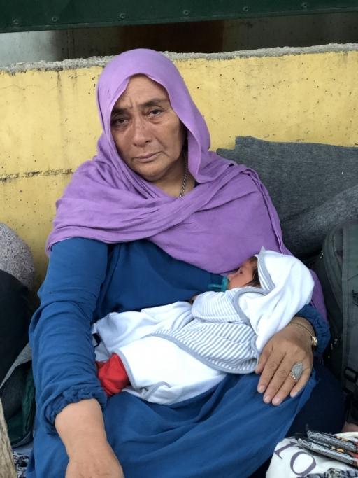 Fatima, a 66-year-old asylum-seeker from Afghanistan, cradles her one-month-old grandchild after they were displaced by a fire in Lesbos' Moria camp.