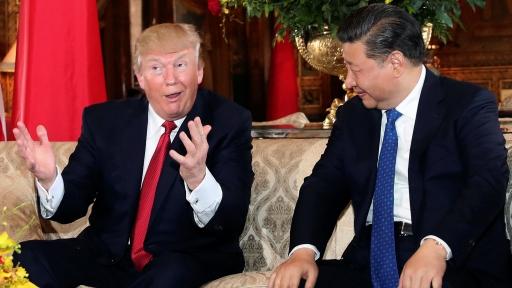 US President Donald Trump throws his hands in the air as he talks with Chinese President Xi Jinping