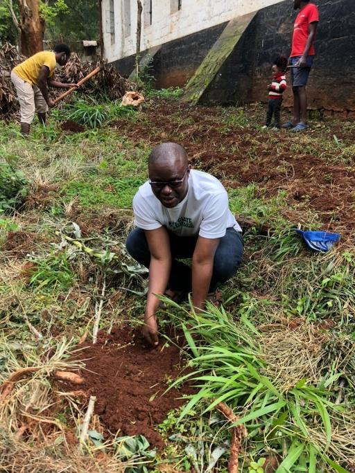 A Kenyan man plants a tree in a forest. 