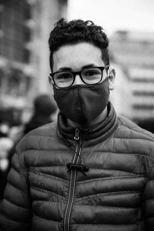 Sixteen-year-old Mohammed Amine wears glasses, a face mask and puffy jacket. 