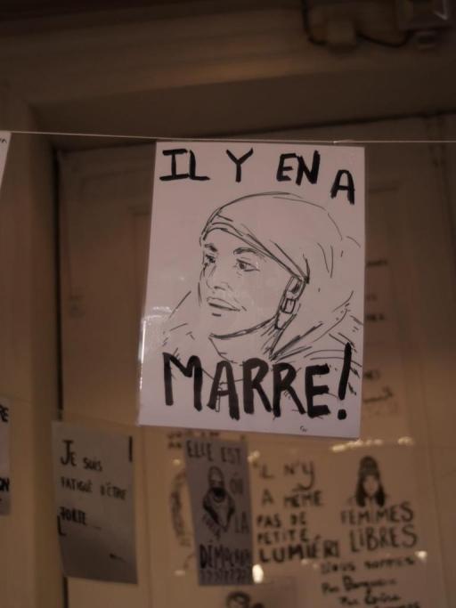 A protest sign reads "Il y'en a marre," or "We've had enough of it." 