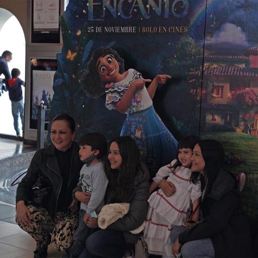 Spectators take a photo in front of an "Encanto" billboard at a cinema Bogotá, Colombia.