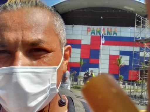 Jose Loya takes a selfie in front of a sign that reads "Panama" along his journey by land to the United States. 