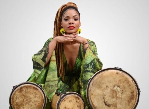 Percussionist and singer Brenda Navarrete posing with batá drums.