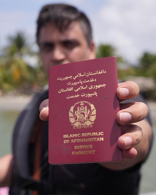 Abdul Bais displays his diplomatic passport, as he gets ready to board a speedboat in Necocli Colombia. Bais worked for Afghanistan's embassy in Iran before the Taliban took over the government.