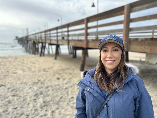 Portrait of Mayor Paloma Aguirre wearing a blue jacket and hat on Imperial Beach in California