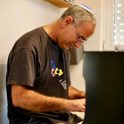Yinon Tsuriely, rapper Noam Tsuriely's father, plays the piano in their Jerusalem home.