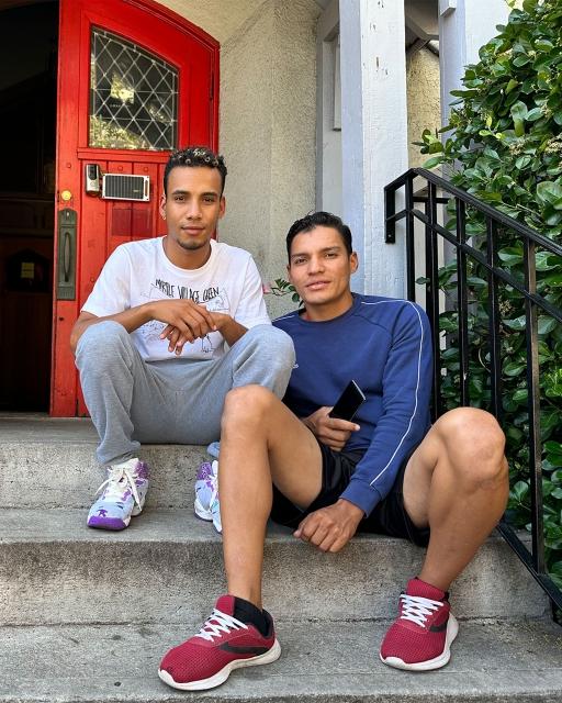 Anderson Fuentes, 24, (left) and Humberto Cortesia, 28, (right), are currently living in a migrant shelter in Queens, New York. They come to the church to volunteer sorting clothing donations and doing other tasks.