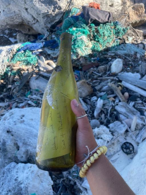 Cassidy Beach holds up the bottle she found on South Caicos island that Pennel Ames had thrown into the water in 2004 from Nantucket, Apr. 25, 2023.