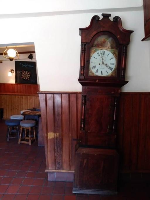 A grandfather clock looks like it's leaning but it's standing perpendicular in The Crooked House pub.