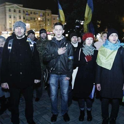 Alexander Khrebet stands with a Ukrainian flag wrapped around him during the Maidan protests in 2013. 