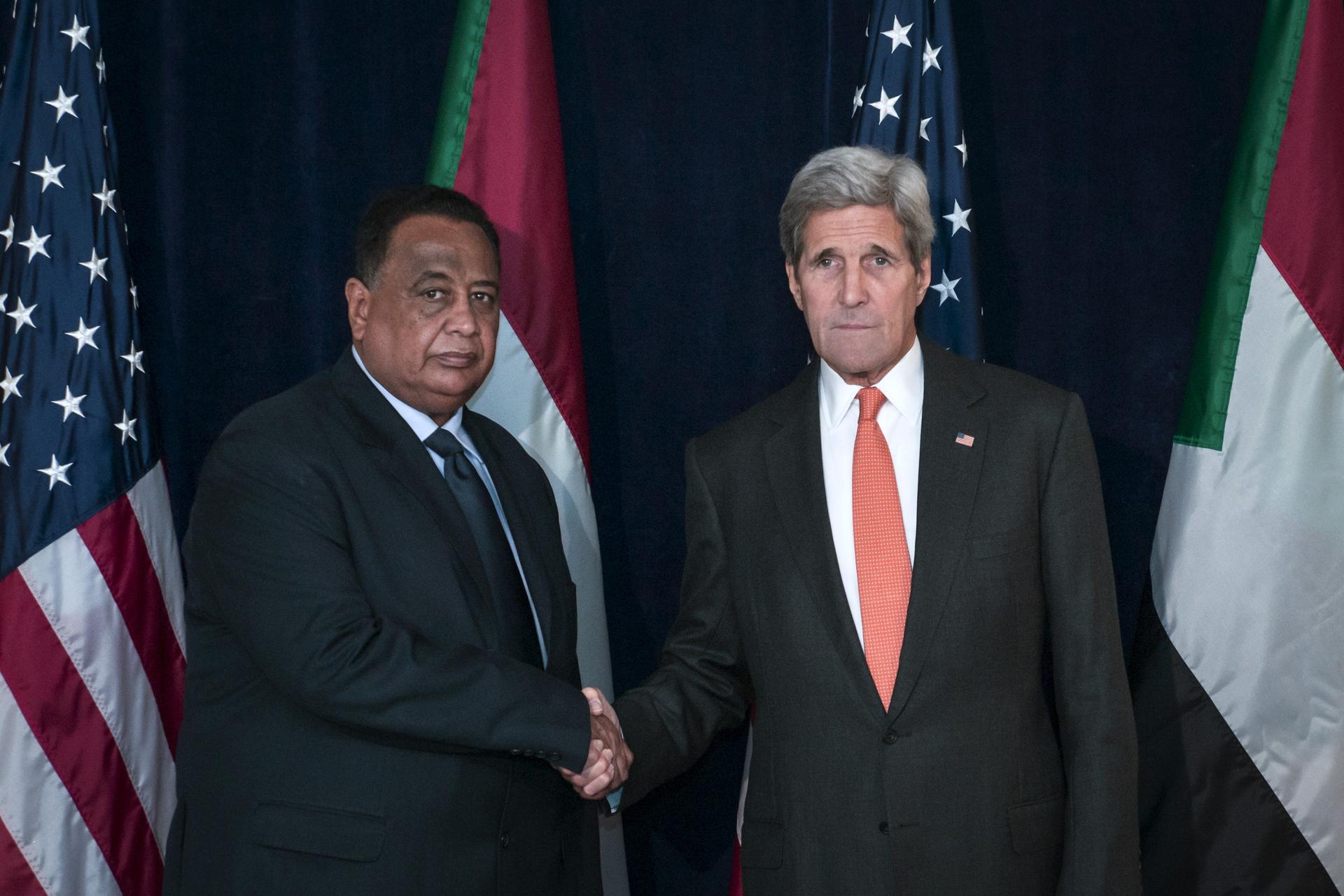 US Secretary of State John Kerry shakes hands with Sudanese Foreign Minister Ibrahim Ghandour as they pose for photos at the Palace Hotel in New York, Oct. 2, 2015.