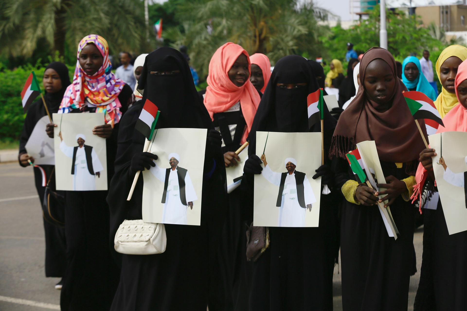 Supporters carry images of Sudanese President Omar al-Bashir during a rally against the International Criminal Court, at Khartoum Airport in Sudan, July 30, 2016. The ICC has indicted Bashir for genocide and other war crimes in connection to the Darfur co