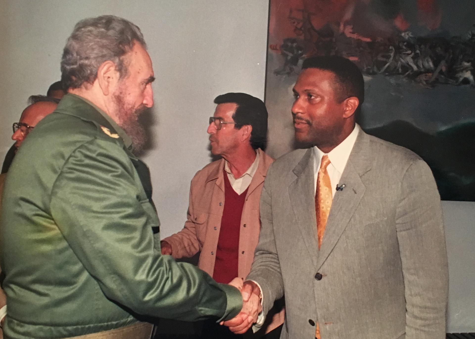 Tavis Smiley and Fidel Castro shake hands.