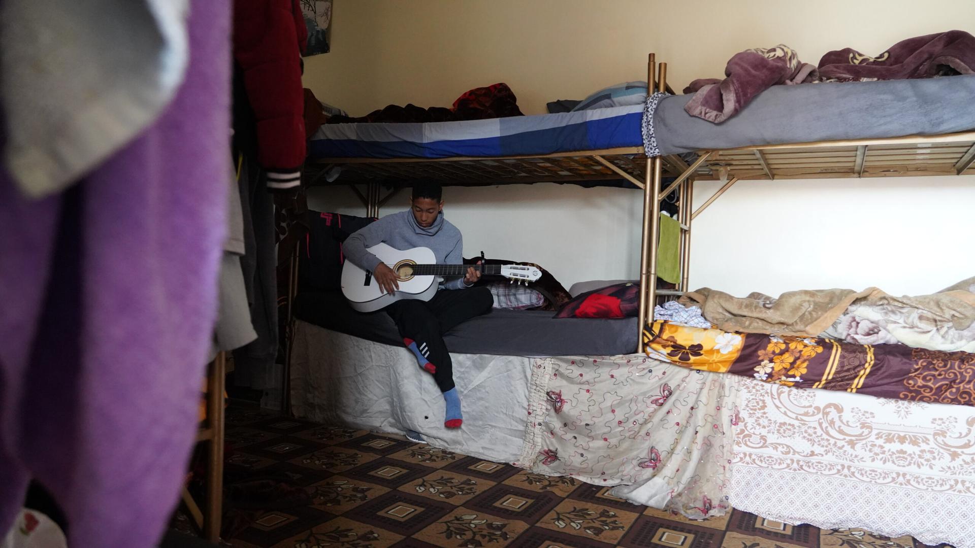 boy in his room playing guitar