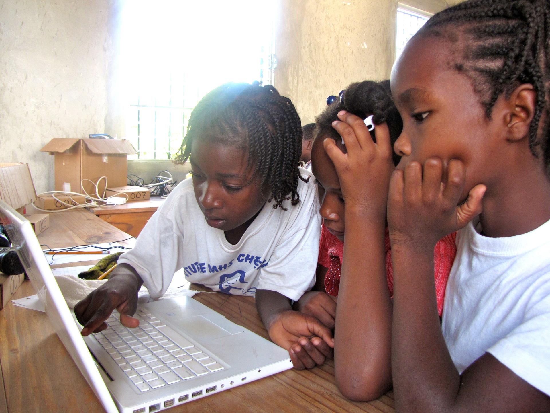 Frandy Calixte, at right, and classmates at the Matenwa Community School learn numeration by playing a pirate video game translated into Creole by linguist Michel DeGraff and his team at MIT.