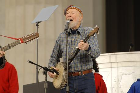 Pete Seeger leads the crowd in singing 