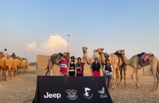 competitive camel racers pose for a picture with their camels