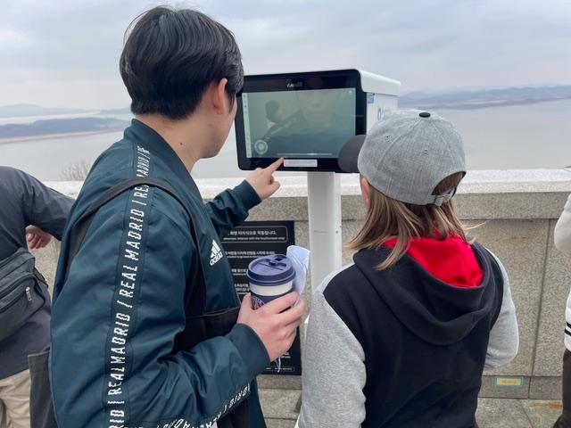 Jun (left) and one of his guests check out a North Korean “propaganda village” located on the other side of the border.
